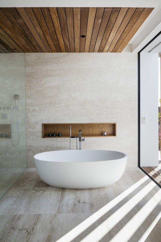 Stylish bathroom interior featuring a large tub and a rich wooden ceiling design.