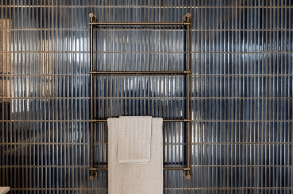 A bathroom scene highlighting a blue tile wall and a towel rack, emphasizing a fresh and contemporary design.