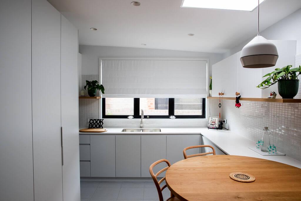 A kitchen featuring a wooden table surrounded by four chairs, creating a cozy dining area.