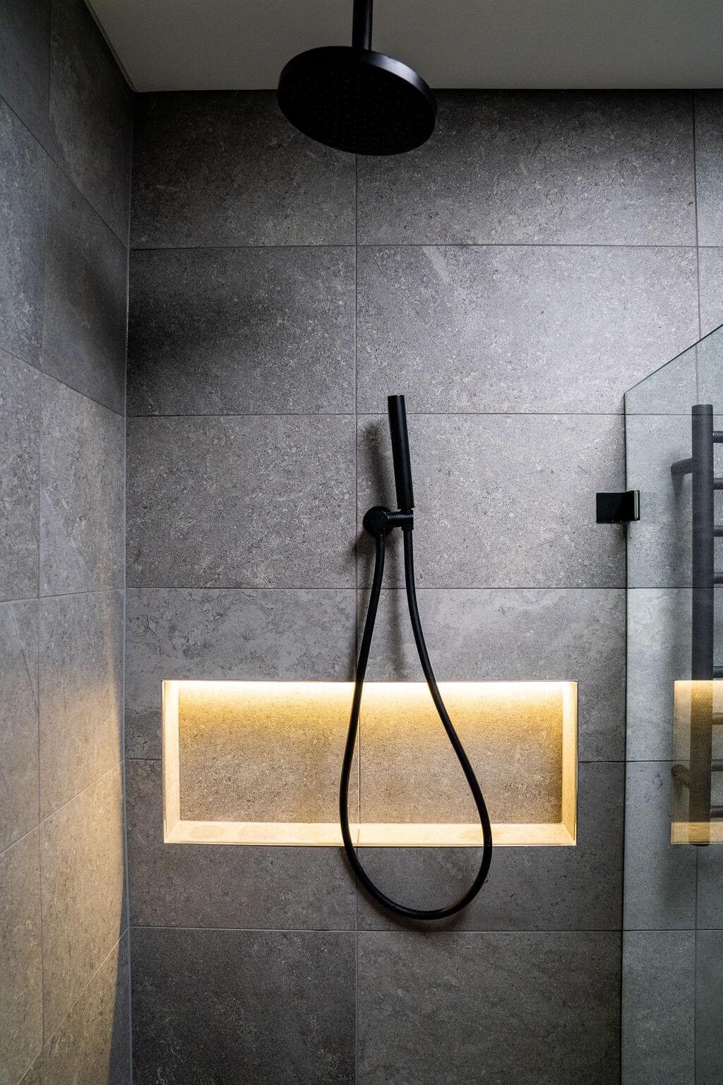Modern bathroom interior with a glass-enclosed shower and a bright ceiling light.