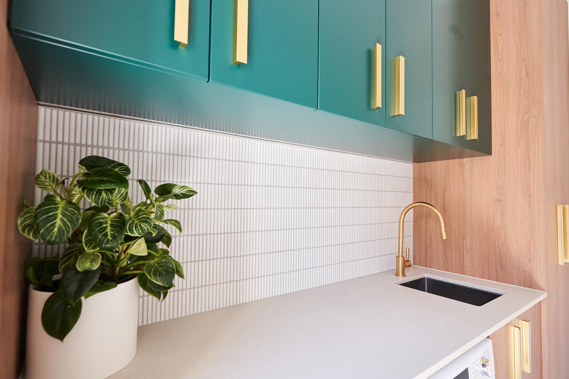 Stylish kitchen with vibrant green cabinets and chic gold hardware accents.