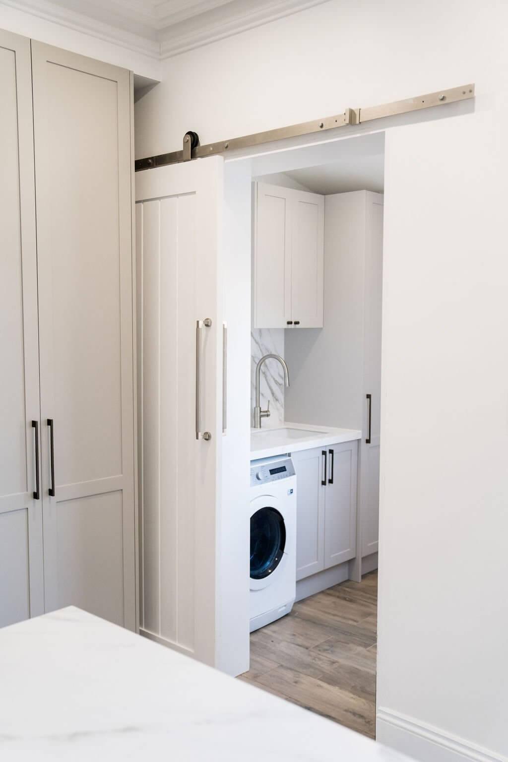 Interior of a laundry room showcasing a washer and dryer, neatly arranged with laundry baskets nearby.