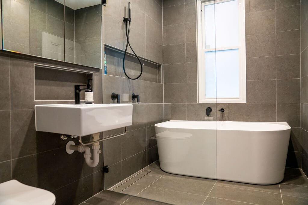 A stylish bathroom showcasing a bathtub, toilet, and a modern sink.