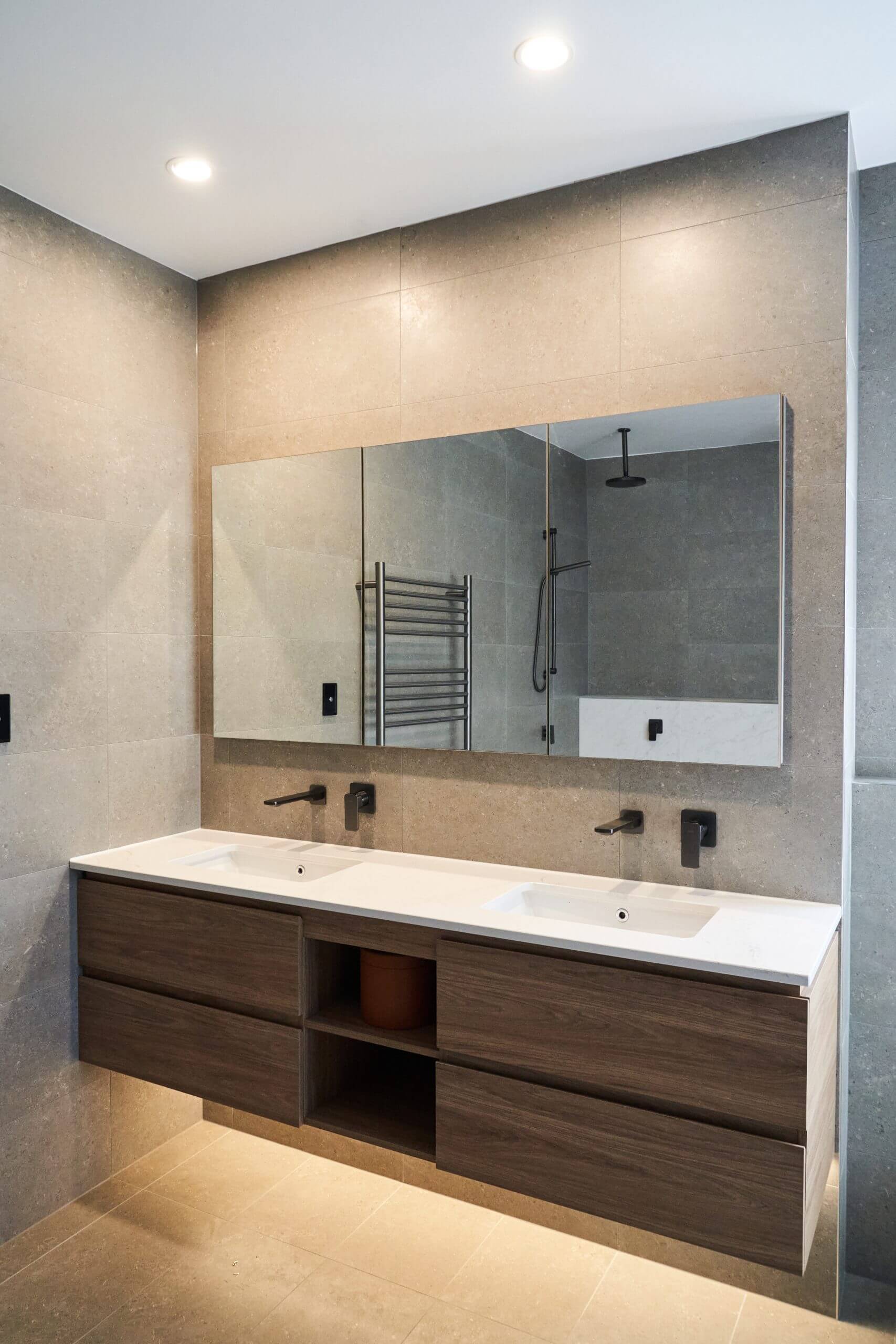 A modern bathroom design featuring a large mirror and sink, reflecting a minimalist and stylish atmosphere.