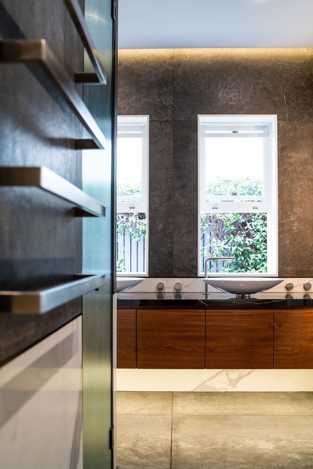 Stylish bathroom interior with a large mirror and wooden cabinetry, emphasizing modern design elements.