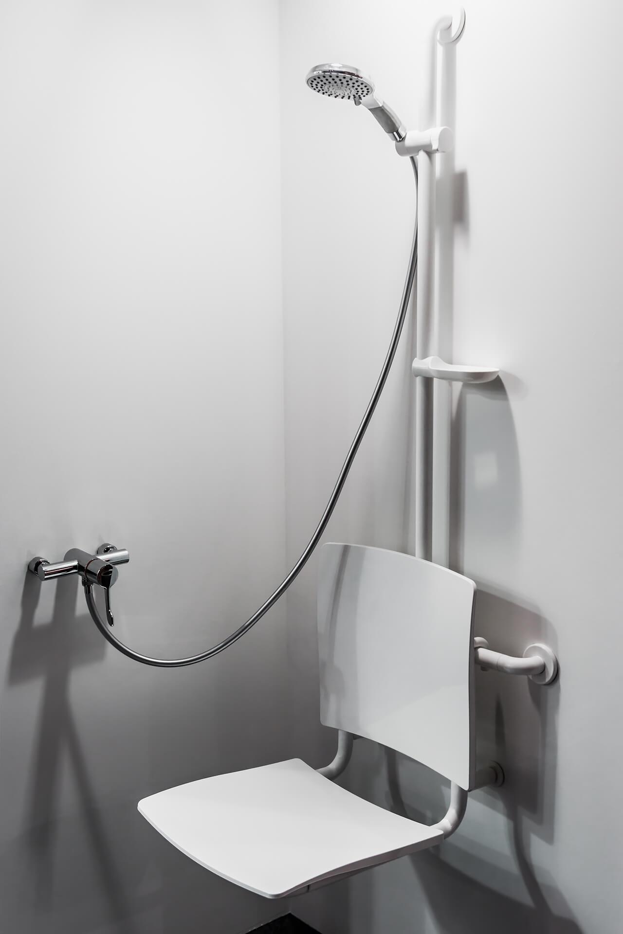 Shower chair with a standard shower head and a handheld shower head for accessible bathing.
