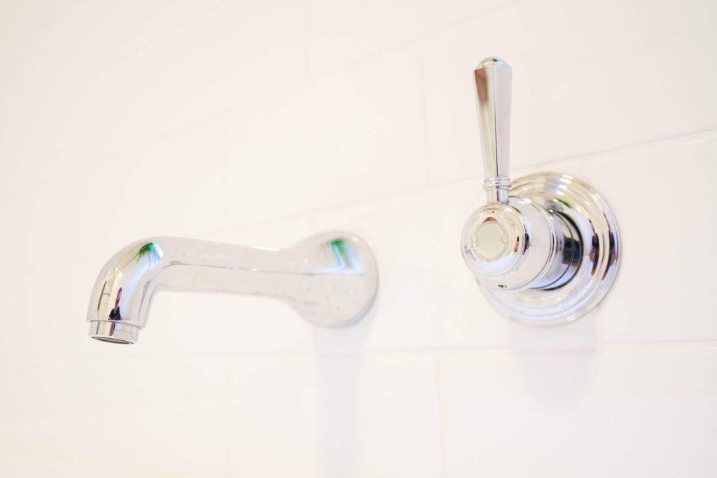 Detailed image of a bathroom faucet showcasing its elegant curves and shiny surface.