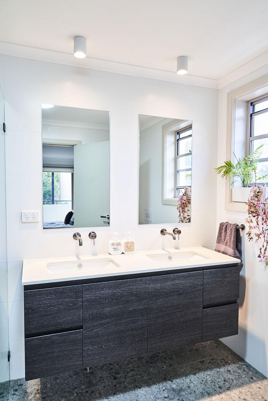 Double vanity with dark timber cabinetry, white countertop and twin mirrors, Newington bathroom renovation