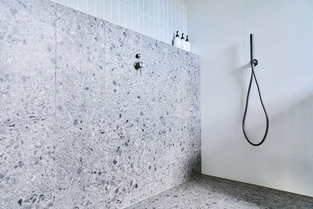 Terrazzo tile close-up with styled amenity bottles on shelf edge