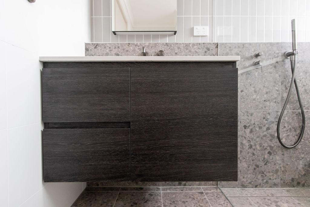 Close-up of dark timber vanity cabinetry grain and finish