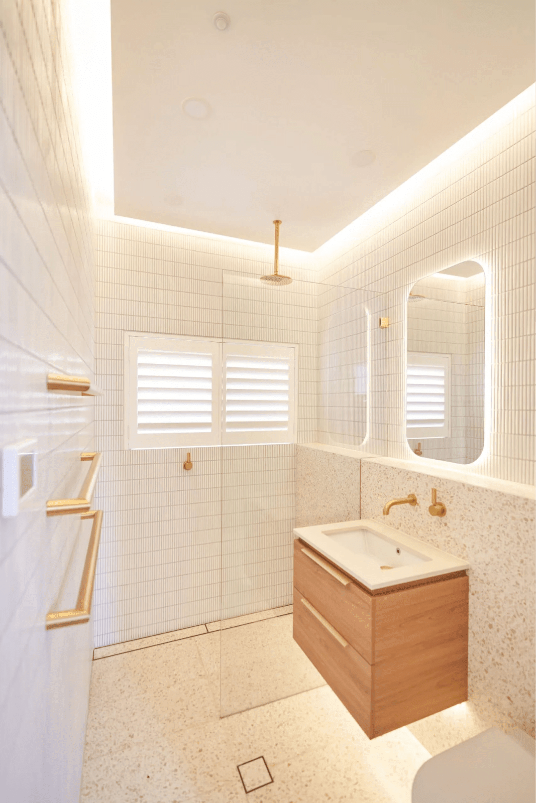 A bathroom showcasing a clean white tiled floor paired with elegant wooden fixtures, creating a modern aesthetic.