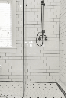 A modern black and white bathroom featuring a standard shower and a spacious walk-in shower area.