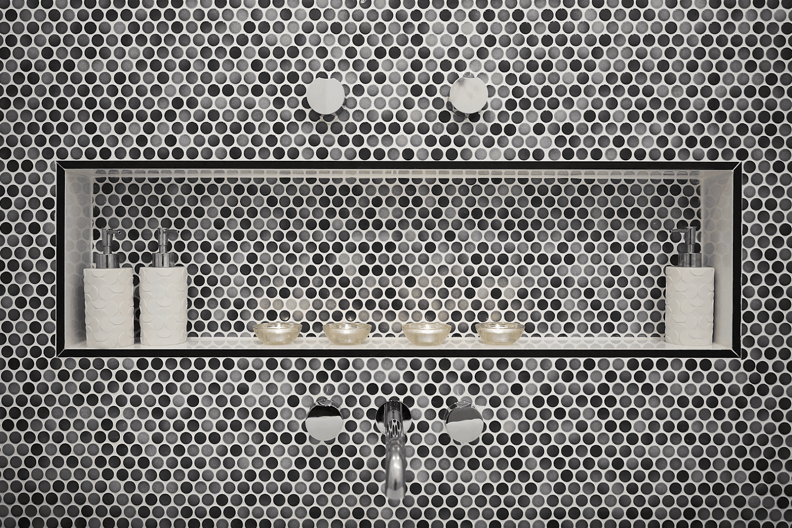 A modern bathroom featuring a striking black and white mosaic wall design.