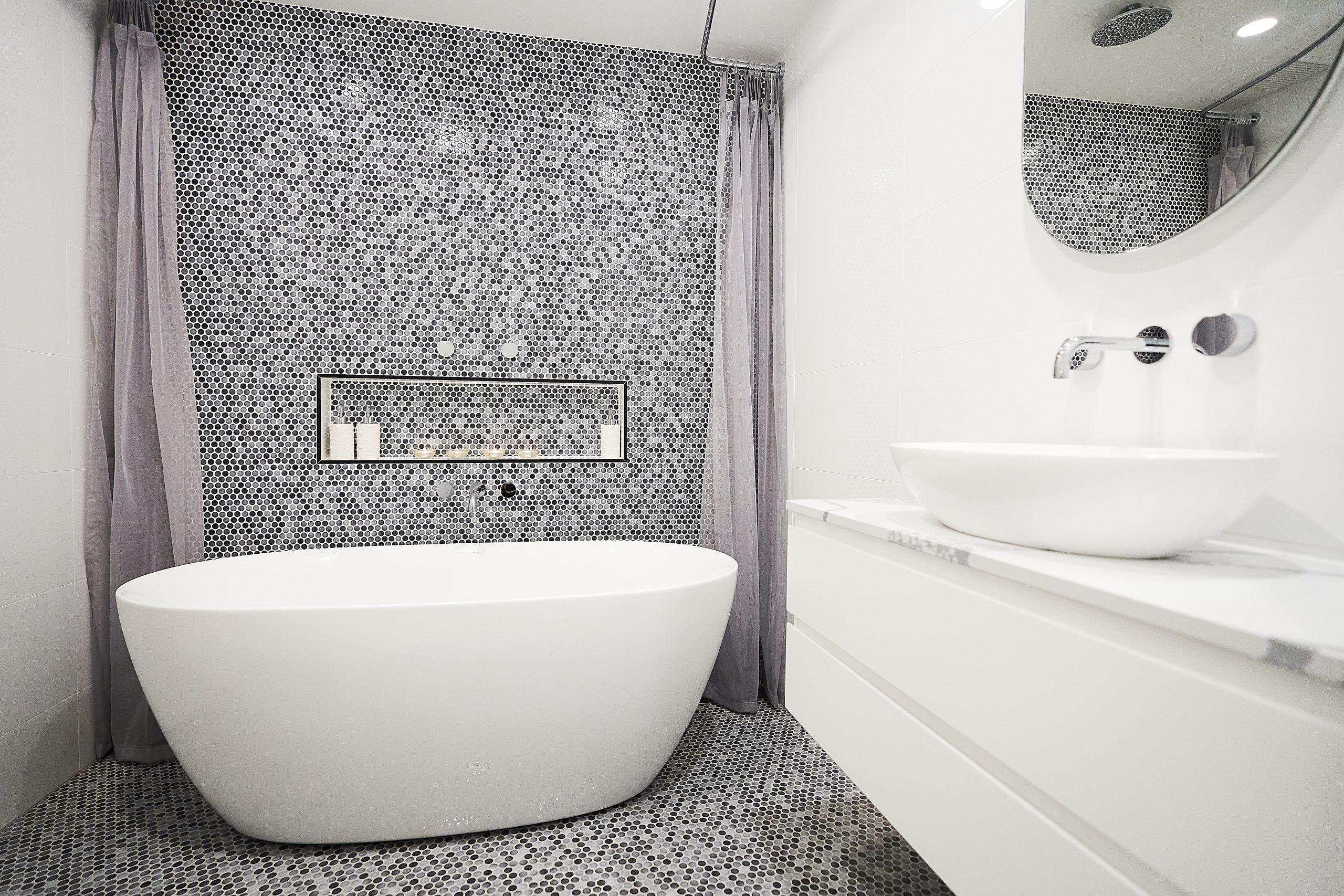 Modern Sydney ensuite with freestanding bath, mosaic floor and wall tiles, wall-hung vanity, and shower niche.