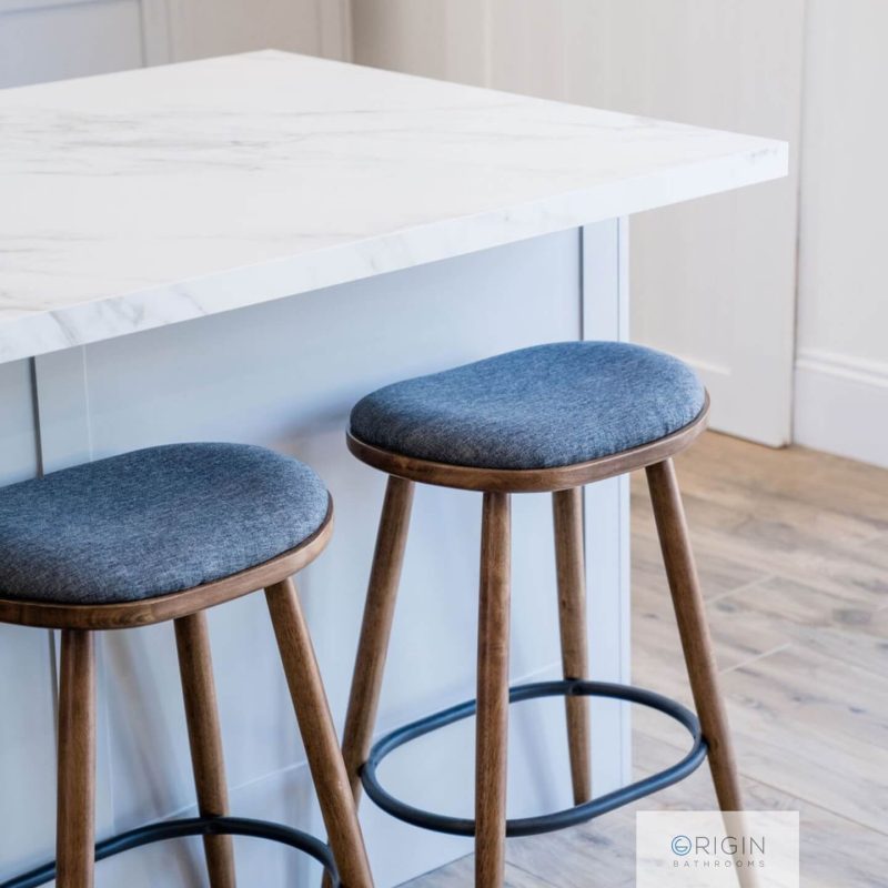 Two modern stools positioned at a marble countertop in a stylish kitchen setting.