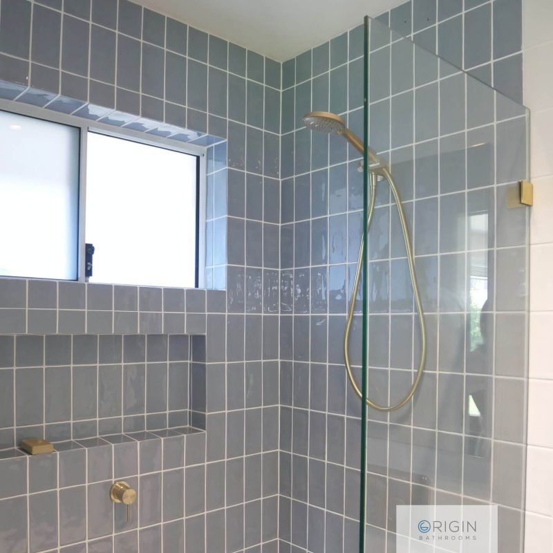 Stylish bathroom showcasing a glass shower and a window, enhancing the space with natural light.