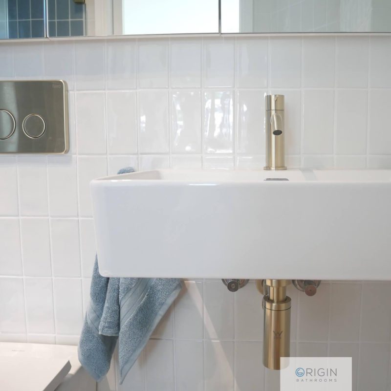 A bathroom sink displaying a towel hanging from the faucet for drying hands.